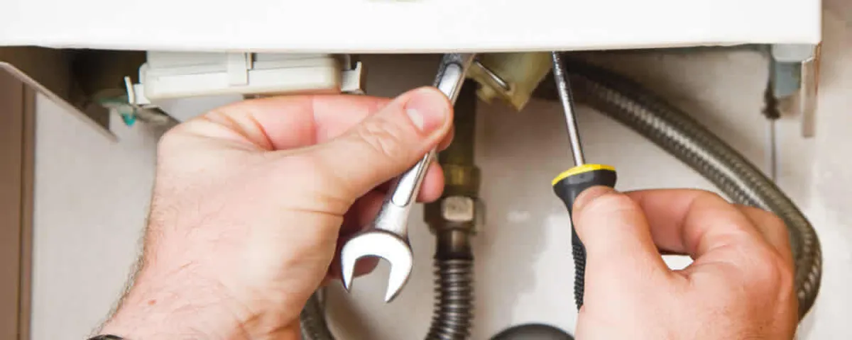 Boiler repair technician tightening pipe fittings and connections in Oak Park, IL